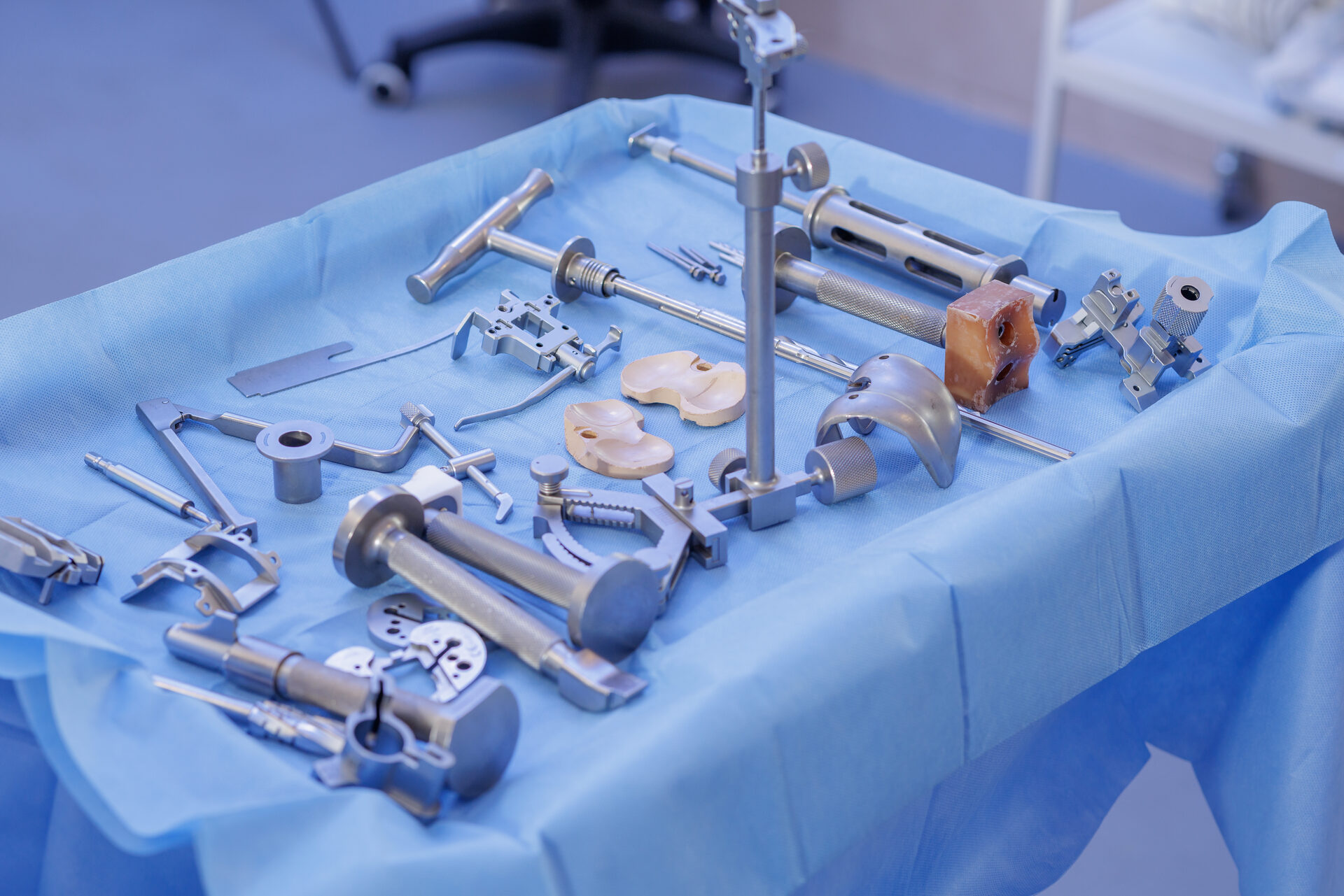Orthopedic surgical instruments arranged on a blue medical drape